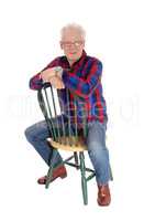 A happy senior man sitting on chair.