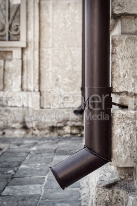 metal drainpipe on the corner of a stone house