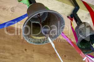 Old brass church bells in a tower tied with colored ribbons