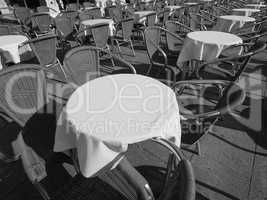 Many tables and chairs in black and white
