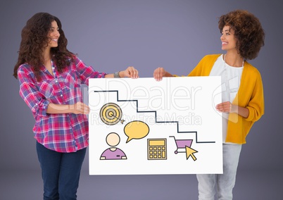 Two women holding card with targets and various graphic drawings