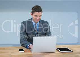 Businessman with laptop against blue background