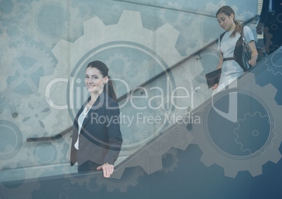 Business people walking down stairs with gear graphics overlay
