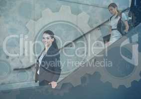 Business people walking down stairs with gear graphics overlay