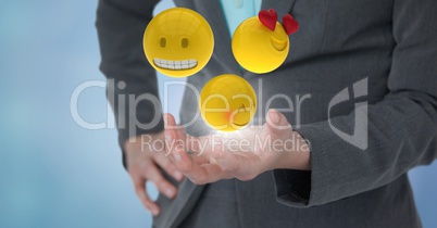 Close up of woman's hand with emojis and flare against blue background