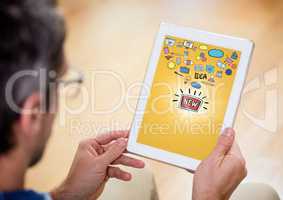 Person with tablet showing idea doodles with flare against yellow background
