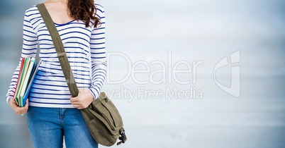 Woman with books and bag against blurry blue wood panel
