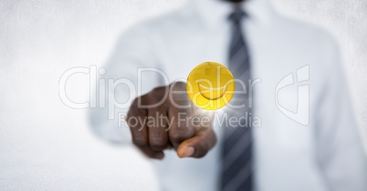 Business man mid section touching emoji with flare against white wall