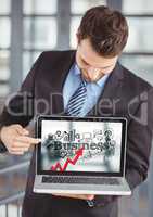 Business man holding laptop showing red arrow with black business doodles against blurry background
