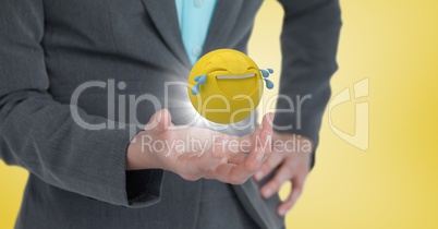 Close up of woman's hand with emoji and flare against yellow background
