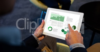 Businessman analyzing graphs on digital tablet