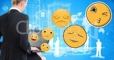 Businesswoman using laptop while emojis flying over blue background
