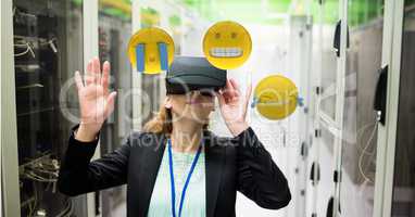 Woman looking at emojis through VR glasses