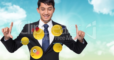 Digitally generated image of businessman looking at flying emojis against sky