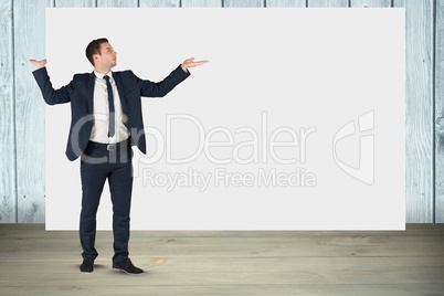 Businessman gesturing while standing against blank billboard