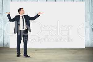 Businessman gesturing while standing against blank billboard