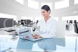 Businesswoman working on laptop with branding sign and icons over desk
