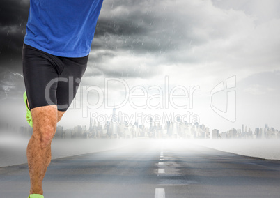 Male runner legs on road with skyline and storm