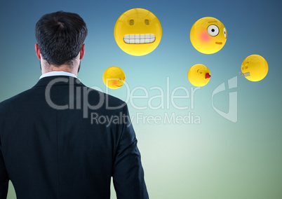 Back of business man with emojis against blue green background