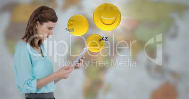 Woman with tablet and emojis with flare against blurry map