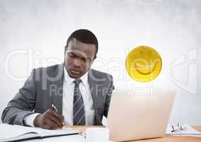 Business man working at desk with emojis and flare against white wall
