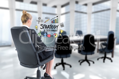 Businesswoman using laptop while strategy sign is surrounded by icons
