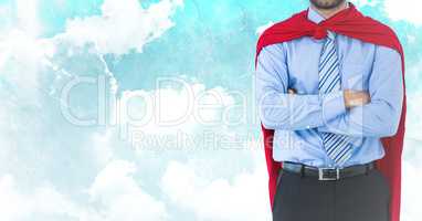 Business man superhero mid section with arms folded against sky