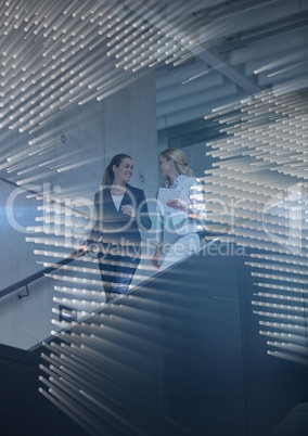 Business women walking down stairs with blue map graphic overlay