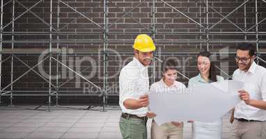 A group of architects looking a blueprint in front of 3D scaffolding