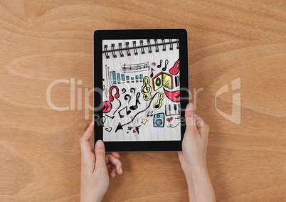 Hands holding tablet showing music doodles on sketchbook