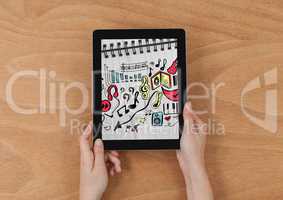 Hands holding tablet showing music doodles on sketchbook