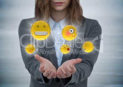 Business woman with hands out and emojis with flares against grey wood panel