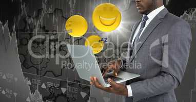 Business man with laptop and emojis with flare against grey chart and gears