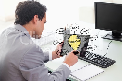 Businessman using tablet PC with various ideas on screen
