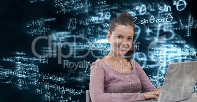 Digital composite image of woman using laptop with math equations in background