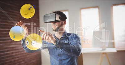 Businessman looking at emojis through VR glasses