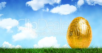 Gold Easter egg in front of blue sky