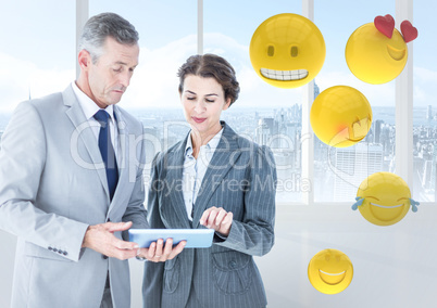 Business people with tablet against window and emojis