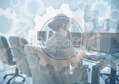 Customer service person at computers behind gear graphic overlay