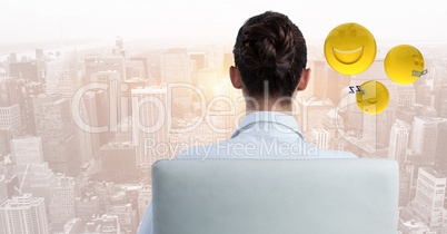 Back of business woman in chair with emojis against blurry skyline