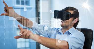 Digitally generated image of various icons with businessman using VR glasses in office