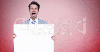 Portrait of businessman shouting while holding blank billboard against pink background