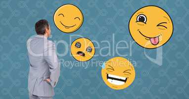 Businessman looking at various emojis