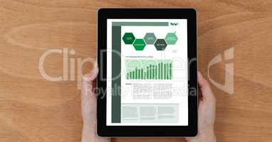 Hands holding tablet PC with graphs