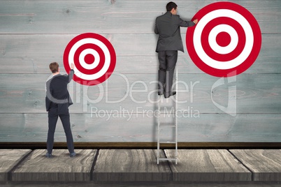 Digital composite image of businessman setting targets on wall