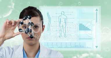 Female doctor holding molecular structure with medical report in background
