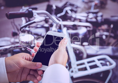 hands with phone with bikes background