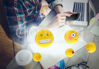Man at desk with phone and emojis with cloud