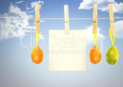 Easter Eggs on pegs with note in front of blue sky