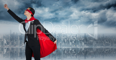Business woman superhero taking off against skyline